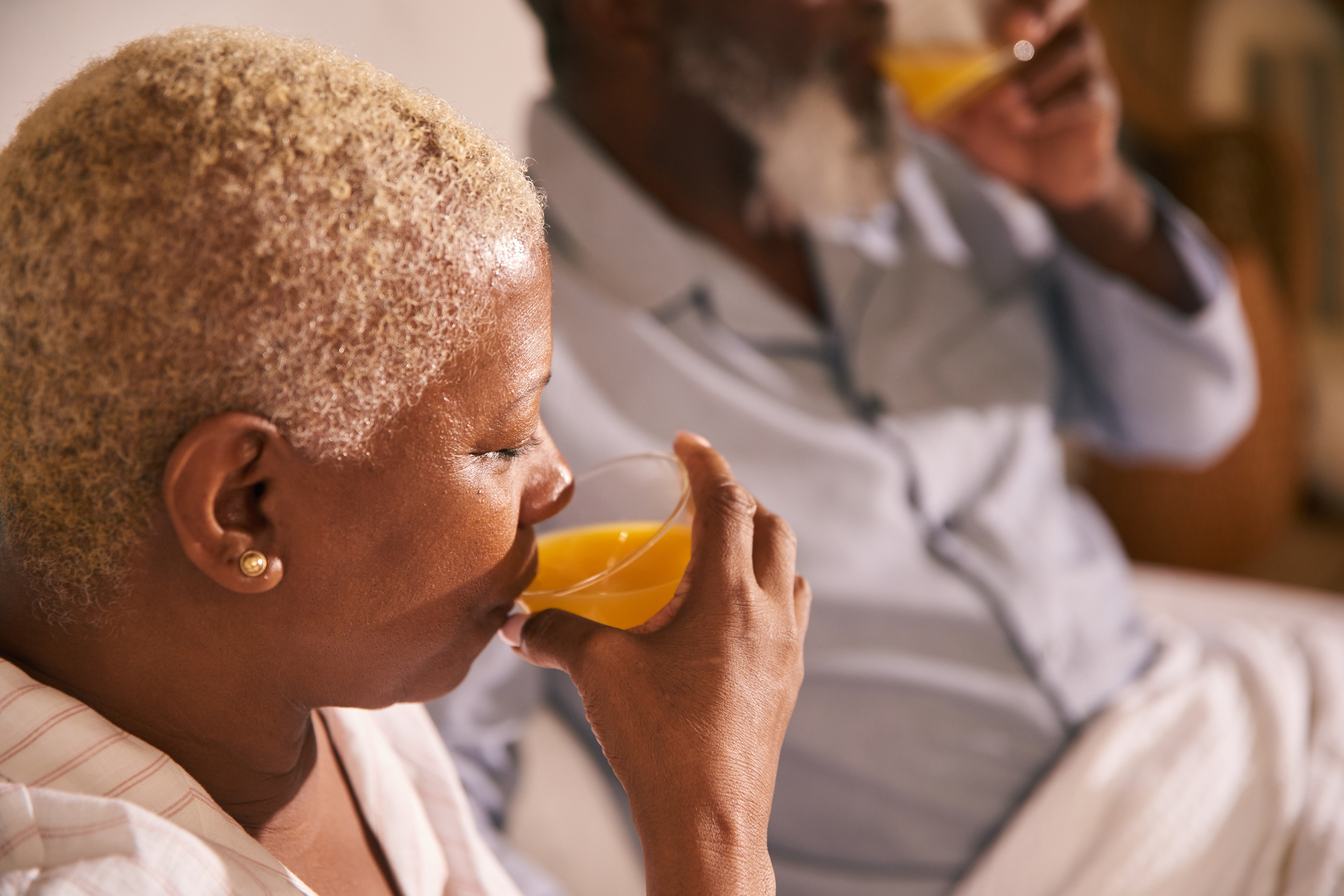 Casal de senhores tomam suco de laranja para se recuperar da gripe pelo Influenza (H1N1)